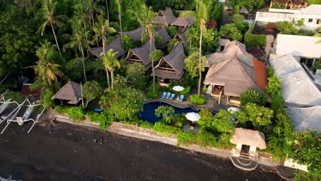 aerial view of a relaxed boutique hotel along amed beach with outdoor swimming pool and lush green landscape in bali