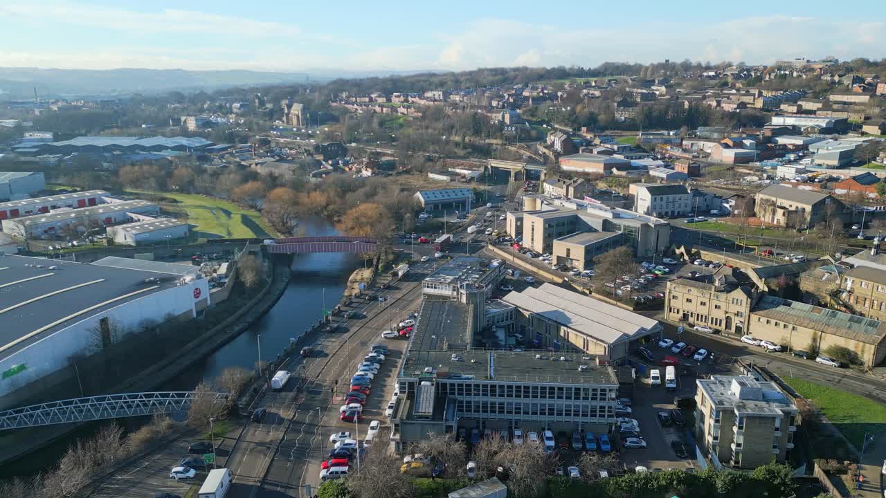 Cinematic aerial footage of a small town in England showing dual carriageway, wide river and busy town with traffic and roads