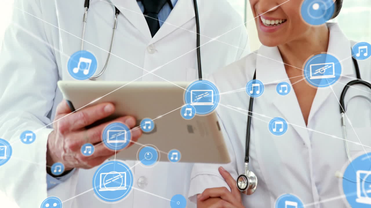 Animation of network of media icons over caucasian female and male doctor using tablet