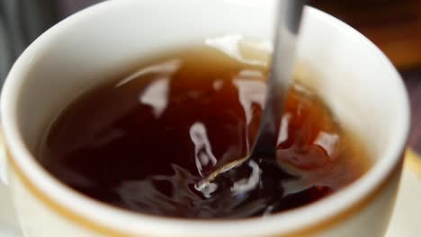 Person-hand-stirring-coffee-with-spoon