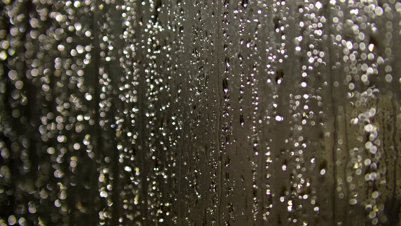 Water Drops following down on dark background