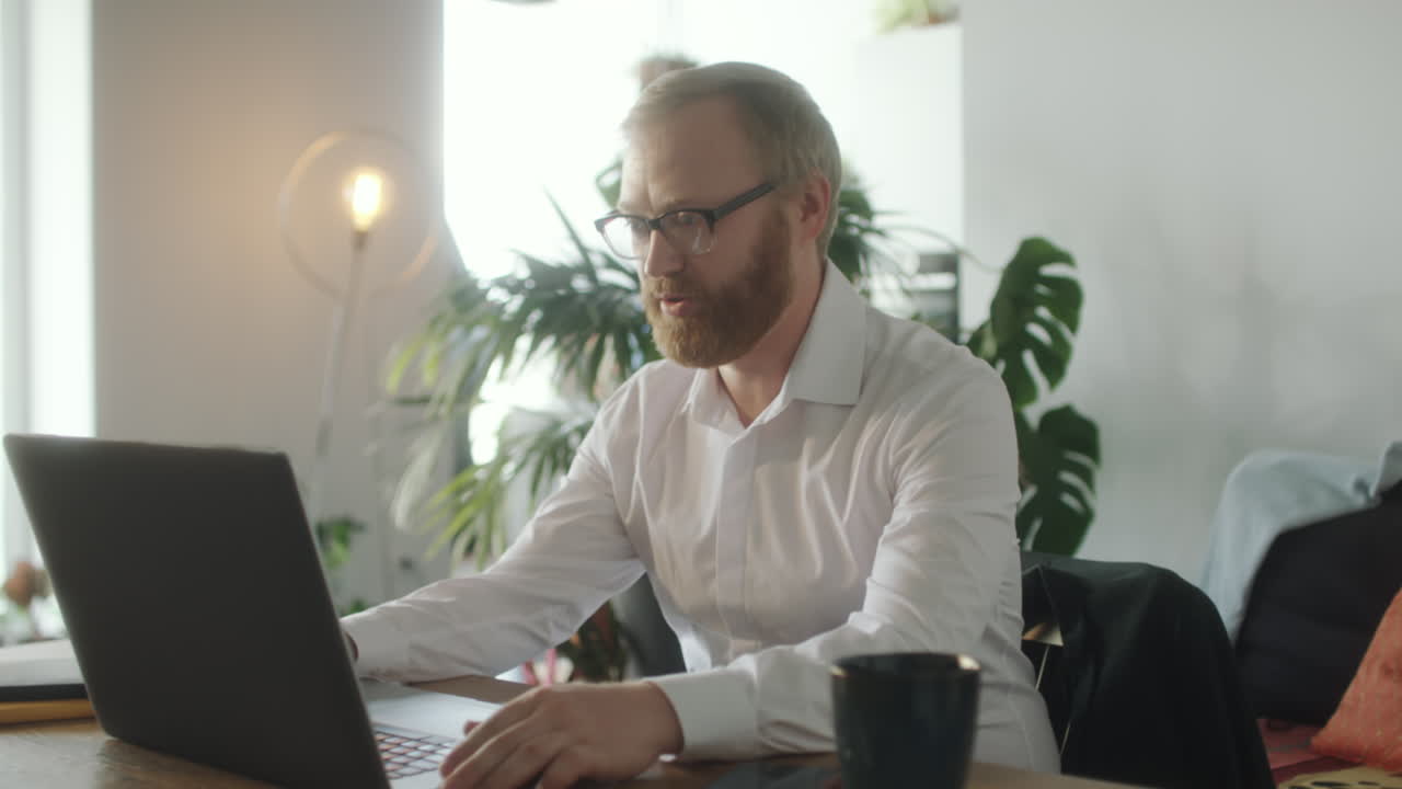 Uomo d'affari in videochiamata che lavora al laptop