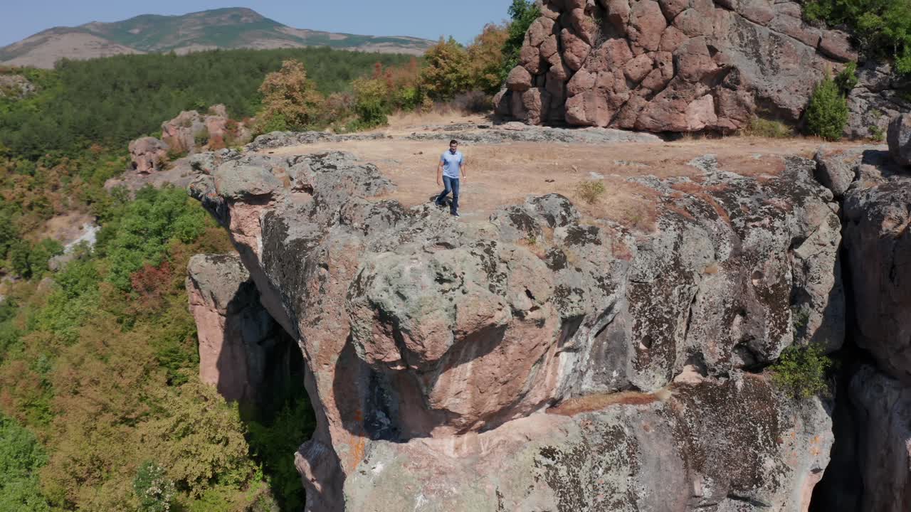 turista masculino caminando en la meseta en el santuario tracio de harman kaya en bulgaria