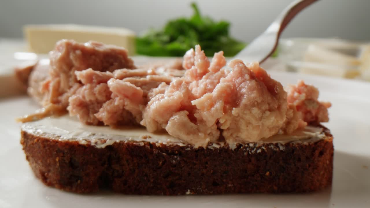 Smoked cod liver in oil in open tin can with fresh greens on wooden table. Seafoods delicacy. High quality 4k footage