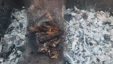 several herring heads bake on curved metal mesh