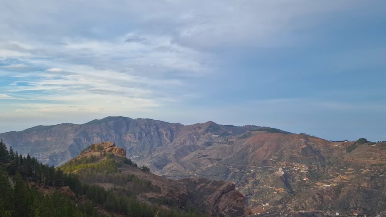 la cordillera de roque nublo en gran canaria españa durante un hermoso día soleado, con valles, picos de montañas y pinos silvestres son visibles. el cielo y el clima está ligeramente nublado, mientras crea sombras.
