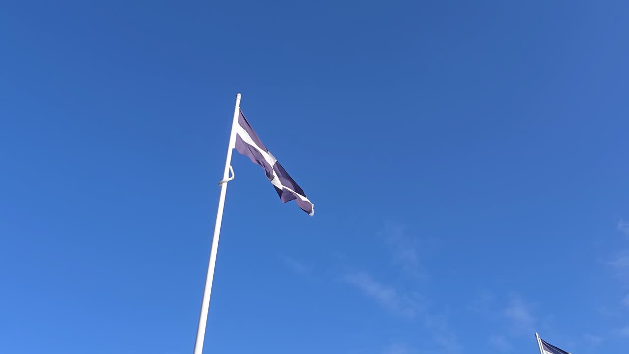 Cornisk flag på stang mod blå himmel i Cornwall, England, set nedefra