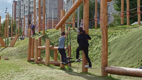 niños jugando en un patio de juegos de madera