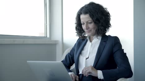 concentrated businesswoman using laptop