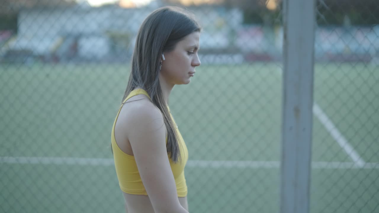 노란색 스포츠 의류 를 입고 야외 트랙 에서 달리는 여자