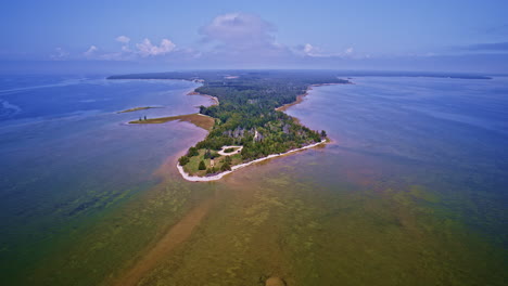 a drone files over a lighthouse situated on teh peninsula extending into lake michigan