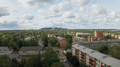 Post-Soviet-town-aerial-shot-of-camera-rising-above-Soviet-buildings-to-reveal-an-industrial-polluting-factory-in-the-background