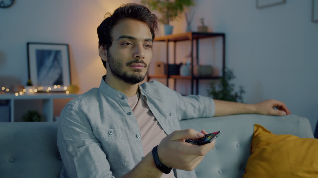 Uomo che guarda la TV sul divano in salotto