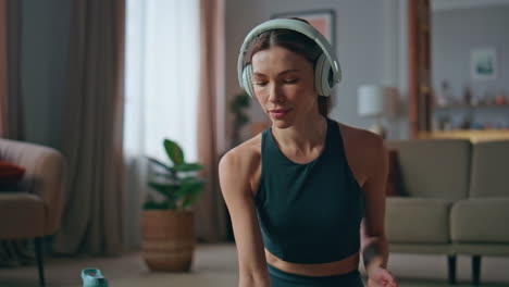 meditative girl listening headphones relaxing sounds in lotus pose home close up