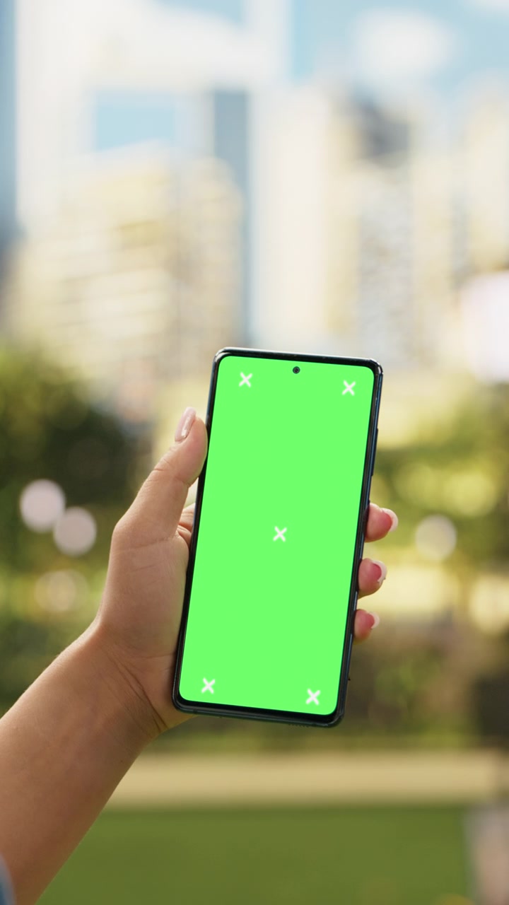 Video verticale. Chroma key verticale con schermo verde su telefono cellulare tenuto da una donna.