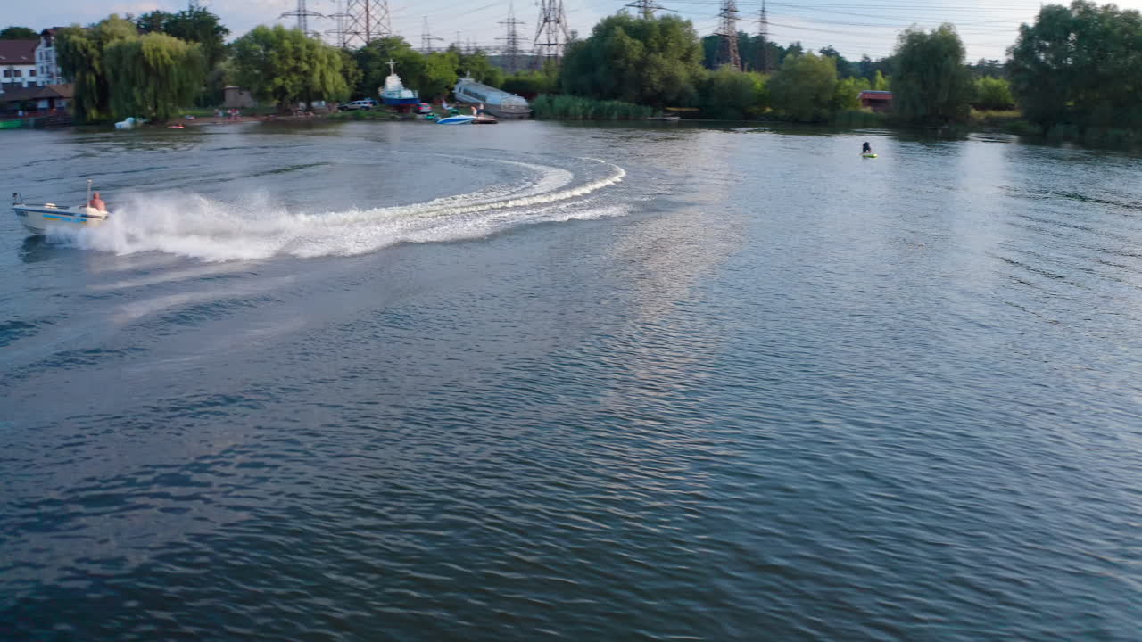 Boats sails along the river. Aerial view of motor boat quickly floats along river