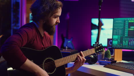 musical performer recording guitar sounds for a new track in home studio