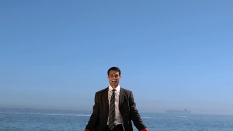 businessman on the beach raising arms