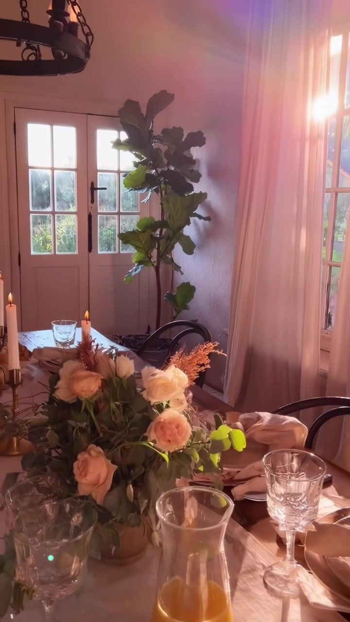 Mesa de Jantar Convidativa com Centro de Mesa Floral e Velas Banhadas em Luz Solar Dourada