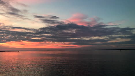 handheld pan of beautiful sunset over calm sea