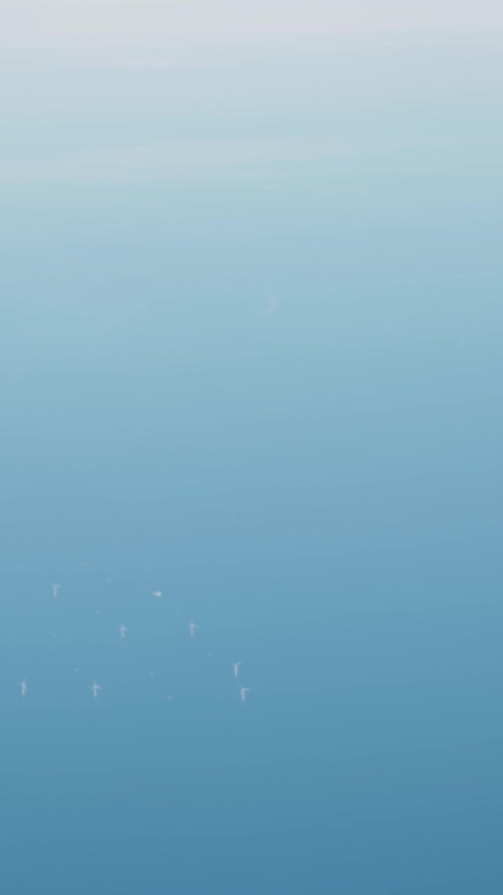 Luftaufnahme aus einem Flugzeug von Offshore-Windkraftanlagen, die über tiefblauem Meer verstreut sind und die Infrastruktur für saubere Energie in einer minimalistischen Meereslandschaft zeigen.