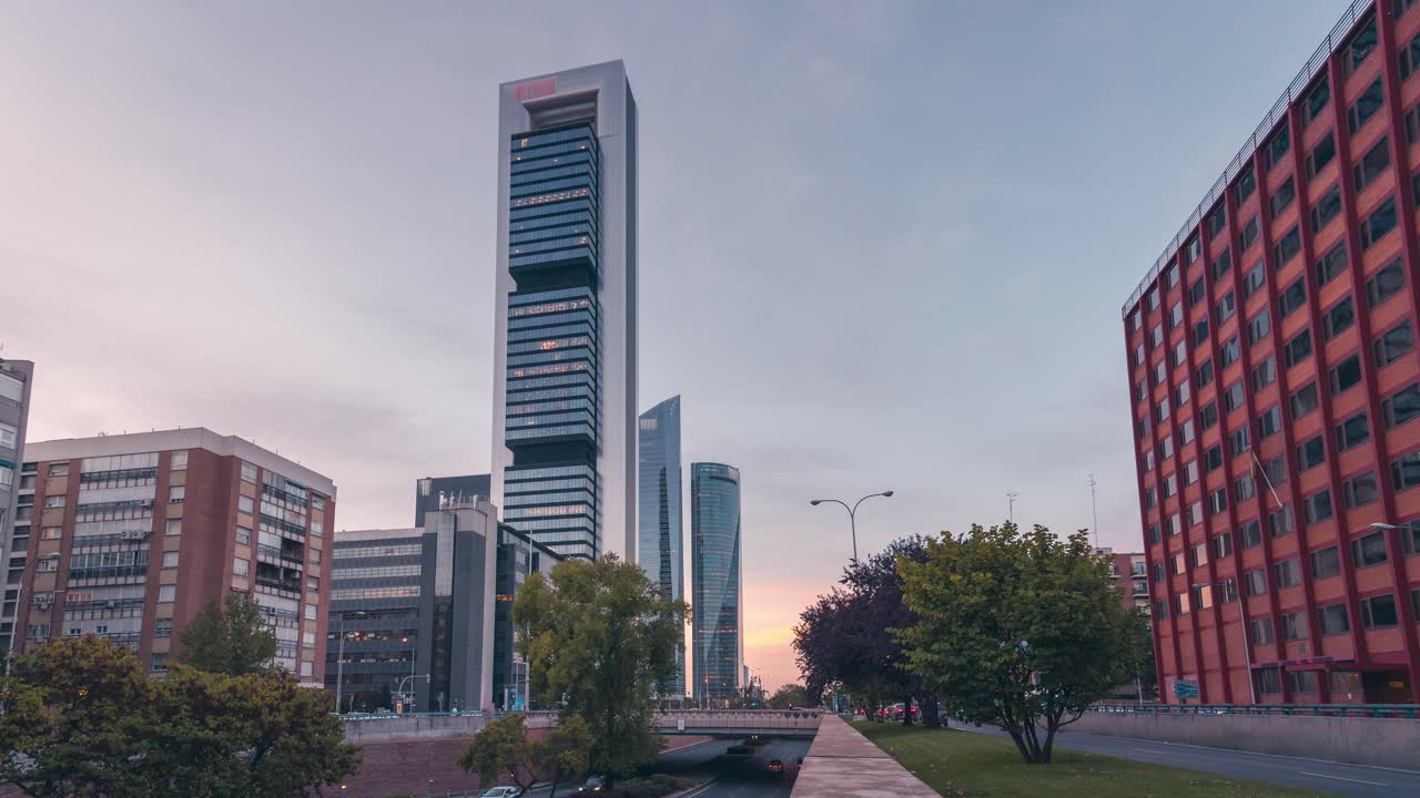 inclinación hacia abajo del día a la noche lapso de tiempo del edificio de rascacielos durante la puesta de sol en madrid, españa área de negocios cinco torres y calle paseo de la castellana