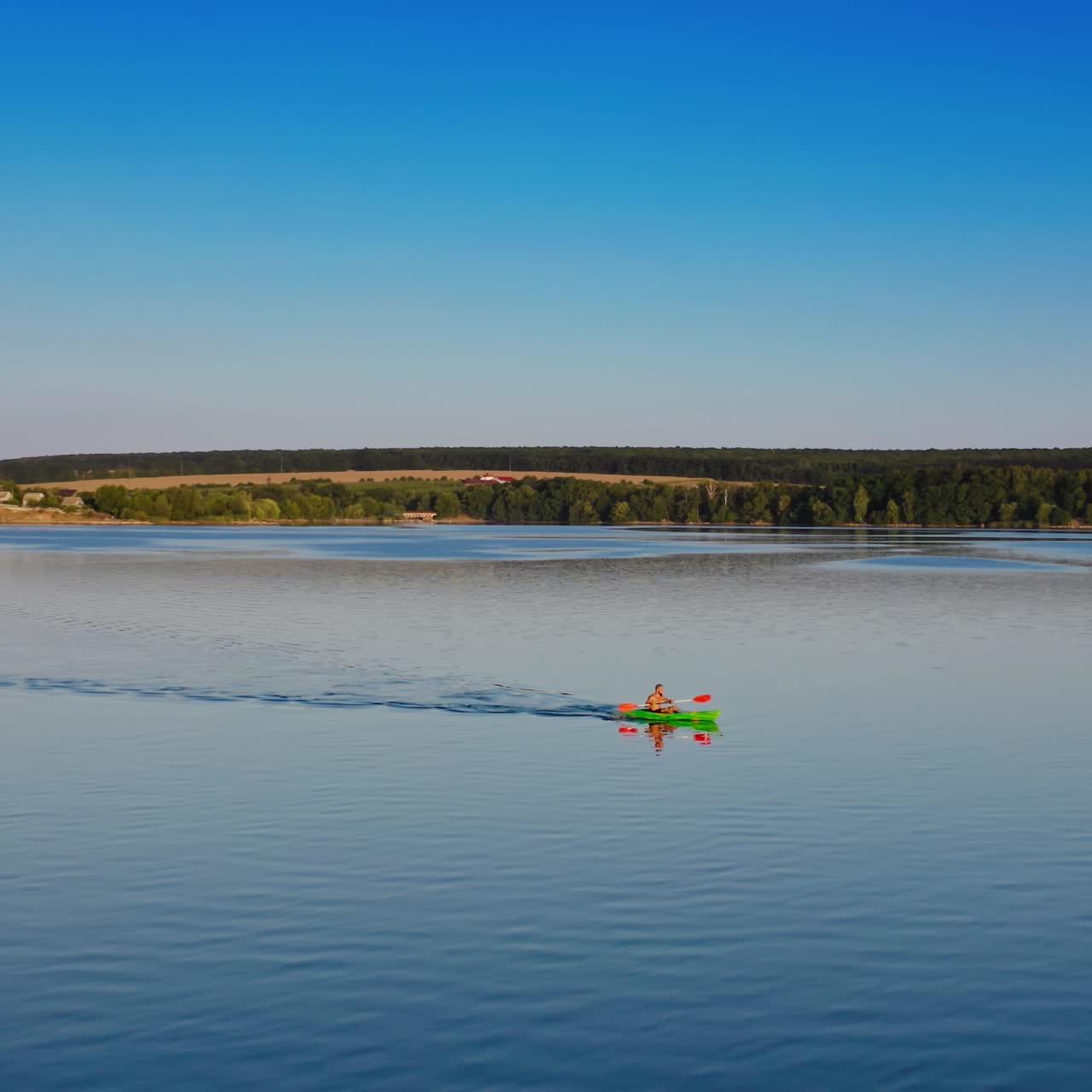 Kayaking in the river. Person in a boat swimming on the evening water. Man rowing at sunset. Motion camera around. Aerial view. Leisure nature concept.