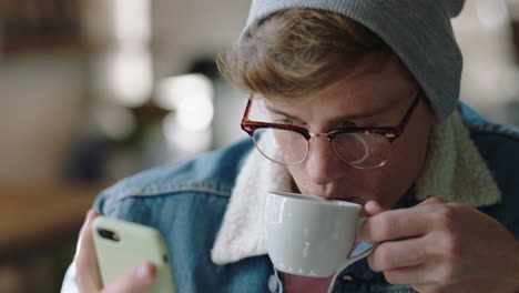 elegante hombre hipster estudiante usando smartphone en una cafetería navegando en línea mensajes de redes sociales disfrutando bebiendo café compartiendo estilo de vida leyendo teléfono móvil comunicación por sms