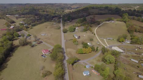 Aerial-fly-over-the-American-rural-landscape-with-rolling-hills,-fields-and-farms---early-autumn-in-Tennesee