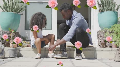 Animation-of-roses-over-african-american-father-tying-shoes-of-his-daughter