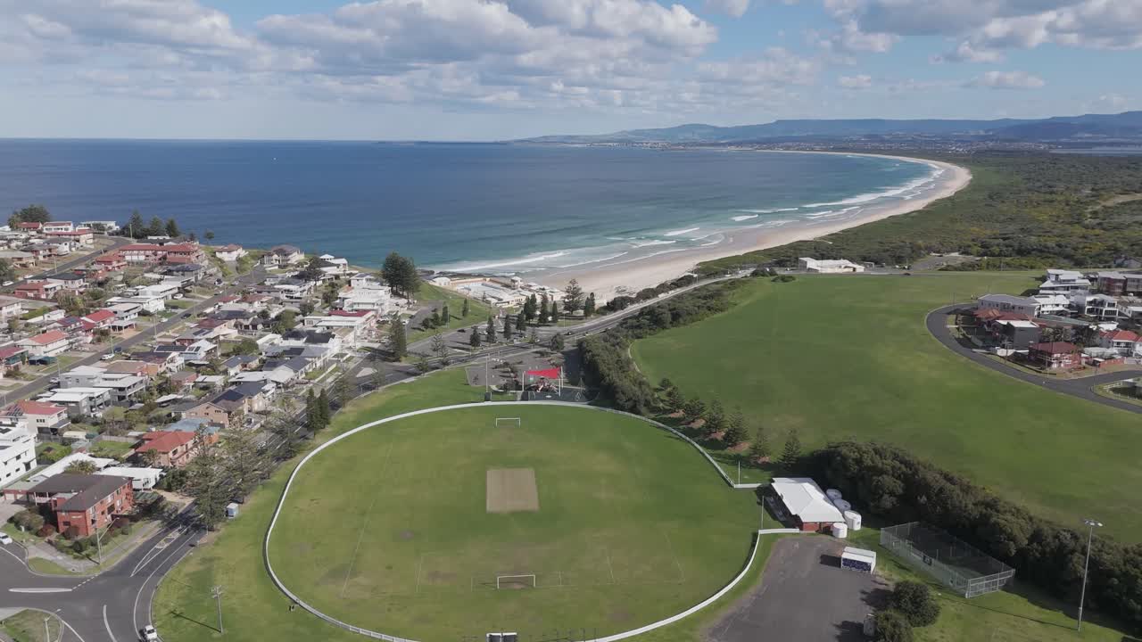 드론은 포트 블라 (port kembla, nsw) 의 주택과 바다 의 다중 용도 운동장과 녹지 공간 위로 기울어집니다.