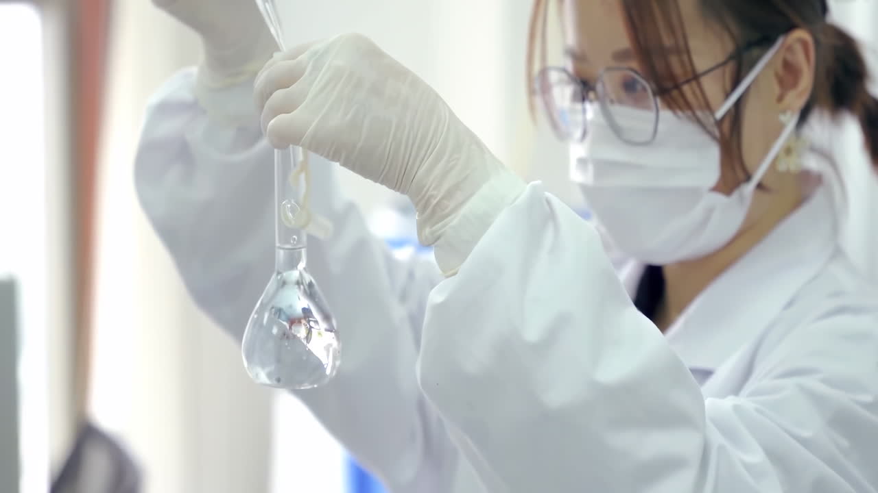 Researcher in medical protective gloves transferring solution Samples to a tissue culture flask with Suction Pipette for cell culture assay in biological cabinet on in cleanroom environmental facility