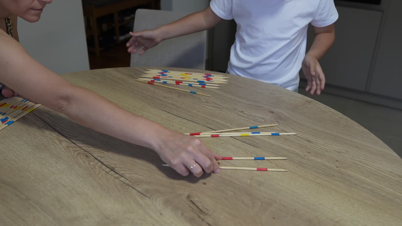Gioco shangai con mano e bastoncini di legno su un tavolo