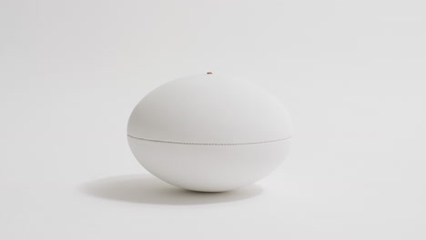 white rugby ball on white background with copy space, slow motion