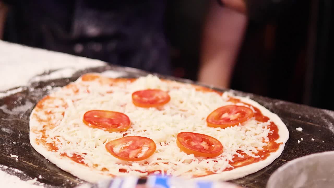 las manos preparan pizza con queso y tomates