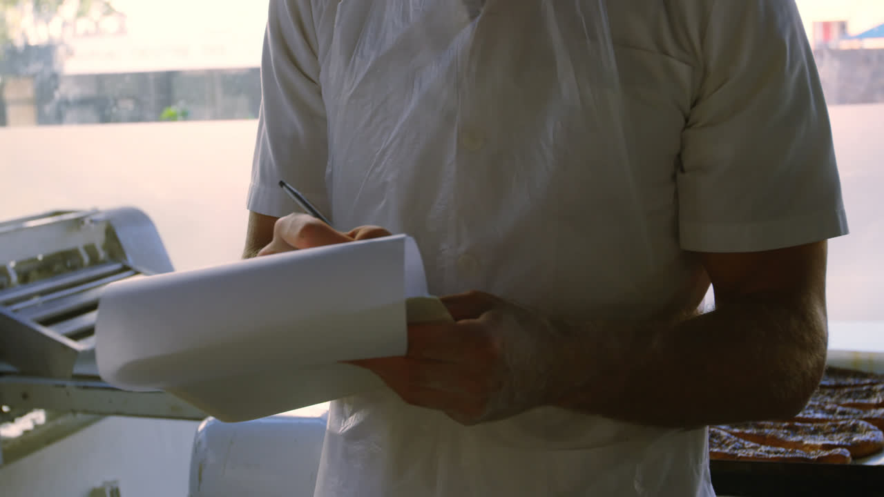 Male chef maintaining records in notepad 4k