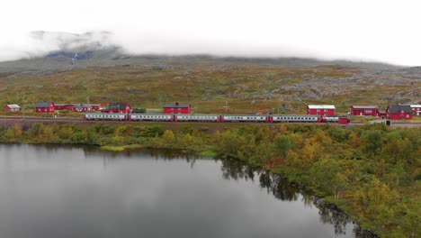 aerial: swedish passenger train by a lake in northern sweden