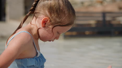 thoughtful little girl in swimsuit rests at exotic resort