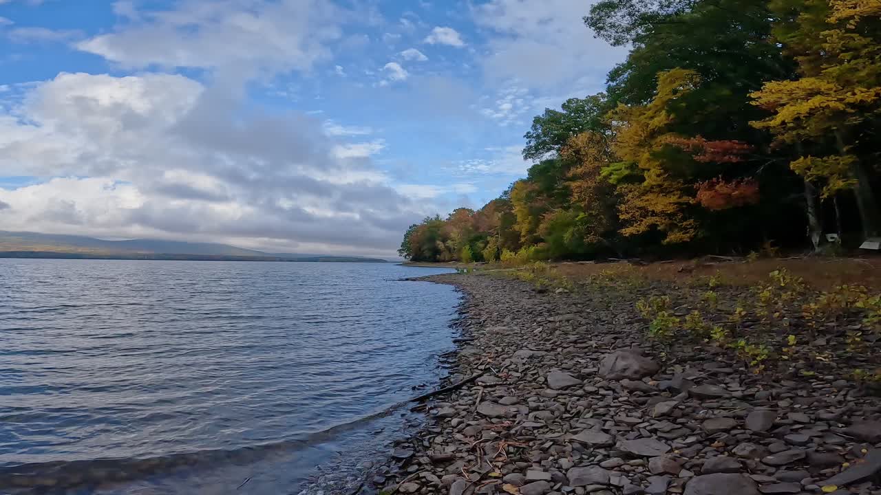 un hermoso día en una impresionante, rocosa orilla del lago de caída con hermosas nubes 60 fps