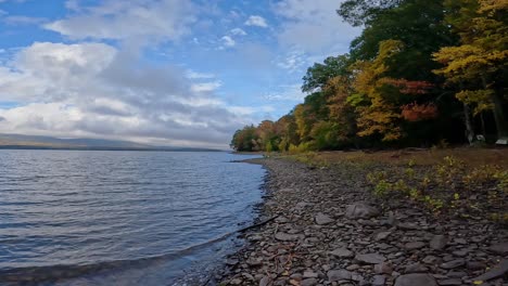 a beautiful day on a stunning, rocky fall lake shore with beautiful clouds 60fps