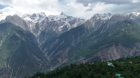 una toma aérea de un dron que destaca los exuberantes valles verdes de kalpa con kinner kailash en la distancia.