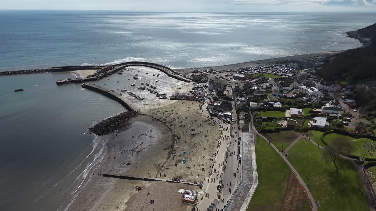 Belebter Strand von Lyme Regis: Drohnen-Luftaufnahme von oben, Devon, Großbritannien.