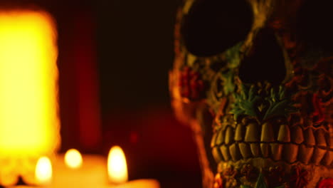 close up on still life of decorated skulls lit by candles celebrating mexican holiday of dia de muertos or day of the dead 6