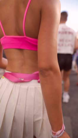 woman in pink crop top and white pleated skirt
