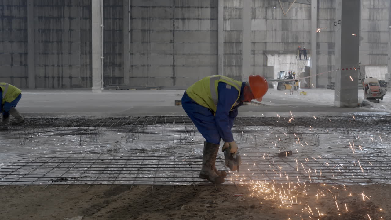 trabajador de la construcción cortando barras de refuerzo en un piso de hormigón
