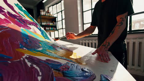 artist painting abstract art with palette knife
