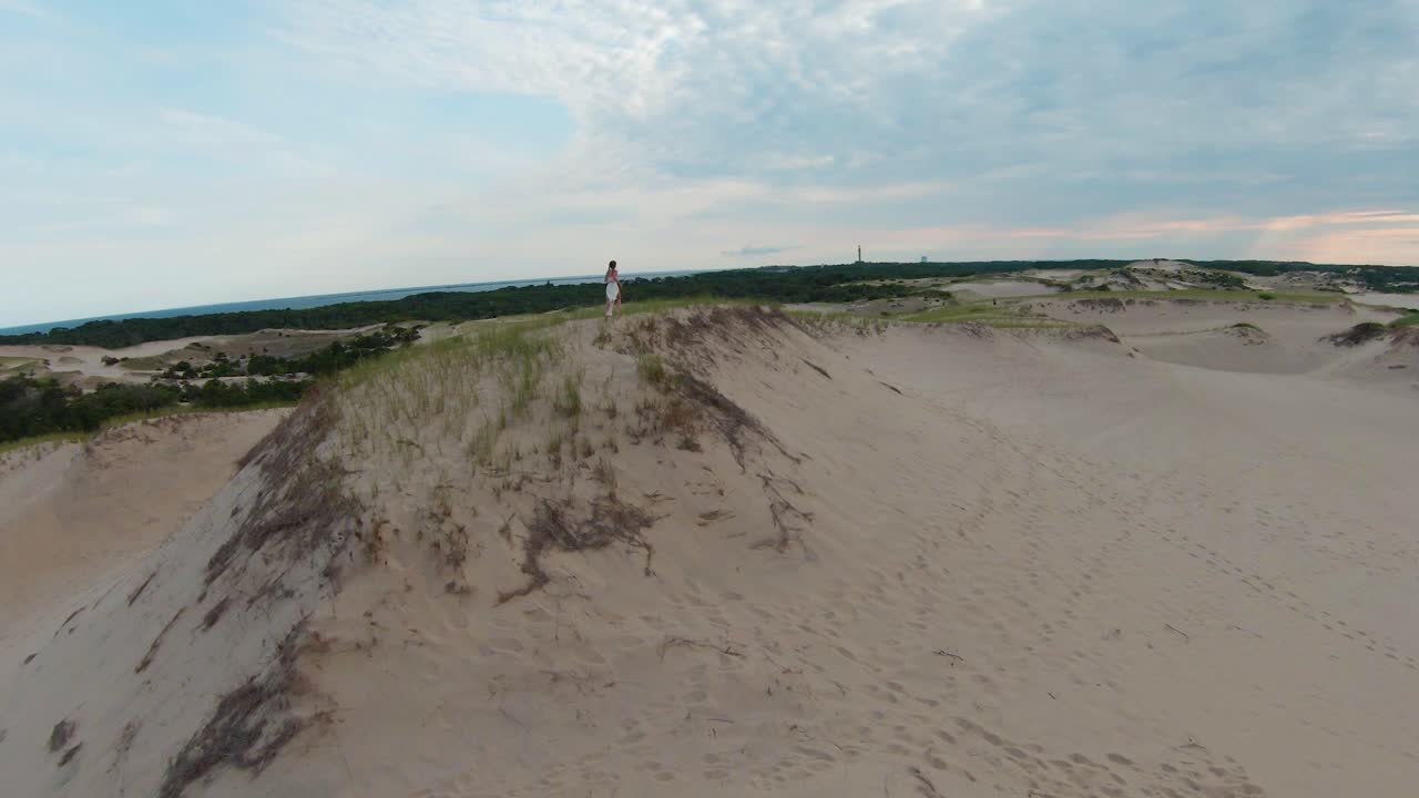 놀라운 황량한 사막 풍경과 매사추세츠 주 케이프 코드 프로빈스 타운의 듄 샤크 트레일에서 높은 모래 언덕과 트레일을 달리는 소녀의 드론 확대 후속 샷