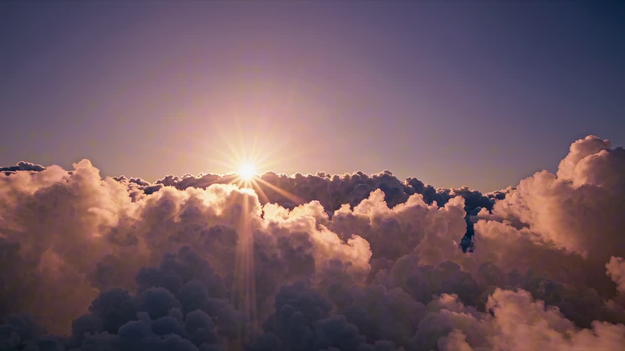 Aerial video view of sun rising over fluffy clouds, capturing a serene and majestic atmosphere
