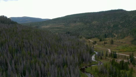 Aerial-cinematic-drone-Piney-Lake-Ranch-Horse-Trails-Vail-Beaver-Creek-Avon-Colorado-Gore-Range-mountain-landscape-late-summer-afternoon-rain-clouds-stunning-peaks-peaceful-calm-upwards-pan-down