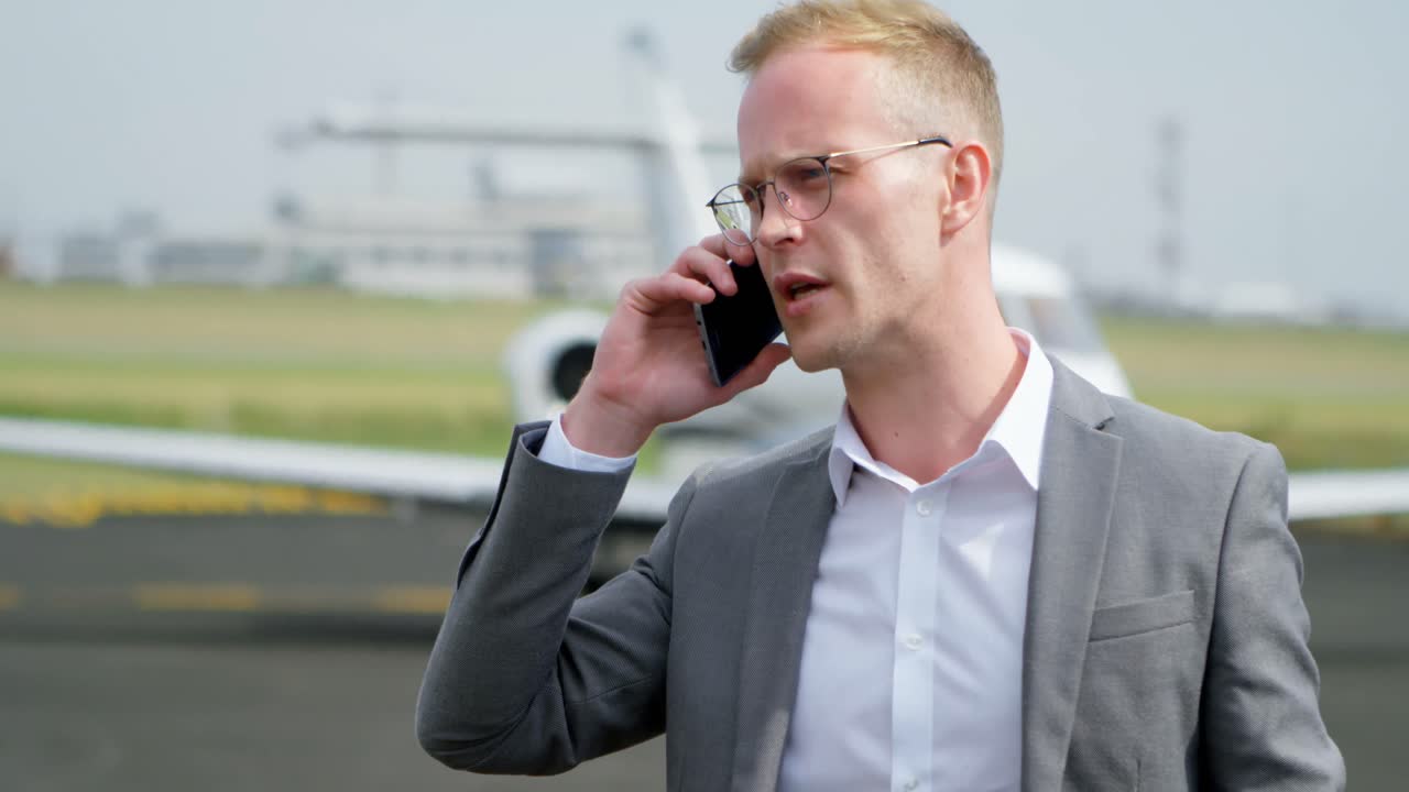 Forretningsmann snakker i mobiltelefon på terminal 4k